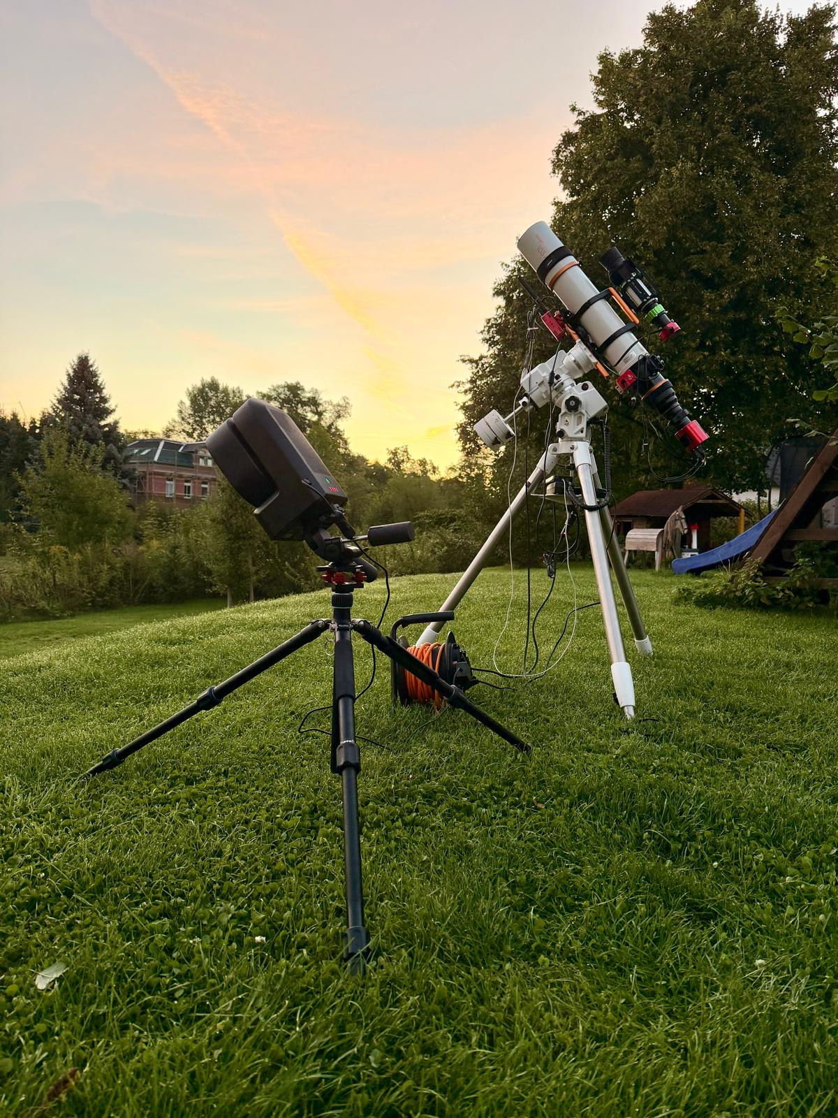 Refractor on a harmonic mount and a Seestar at sunset in a garden